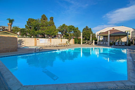 Outdoor swimming pool area with surrounding seating and a covered patio.