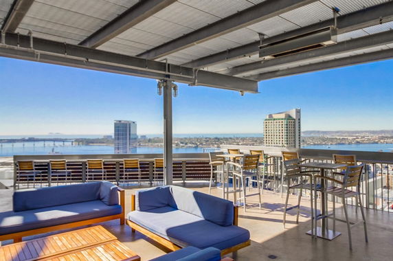 Rooftop with seating and views of city and water.