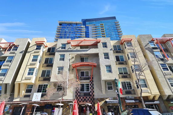 Front view of a multi-story commercial and residential building with distinctive architectural elements.