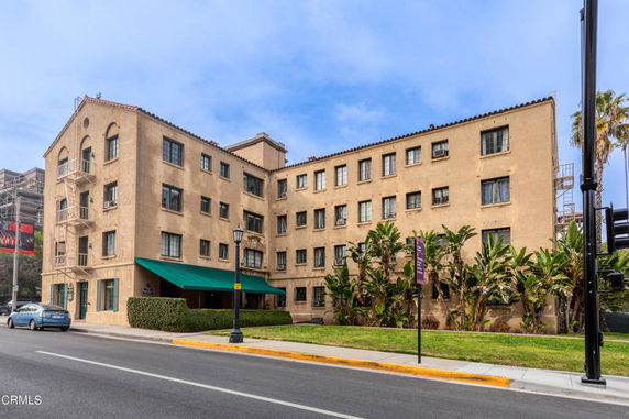 Front view of a multi-story building with a flat roof and awning over the entrance.