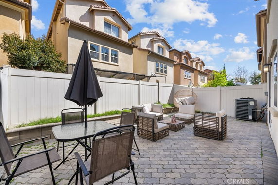 Outdoor patio area with seating and a table, surrounded by residential buildings.