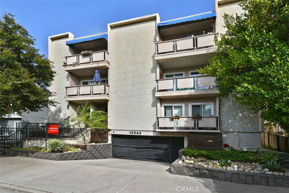 Front view of a multi-story apartment building with balconies.