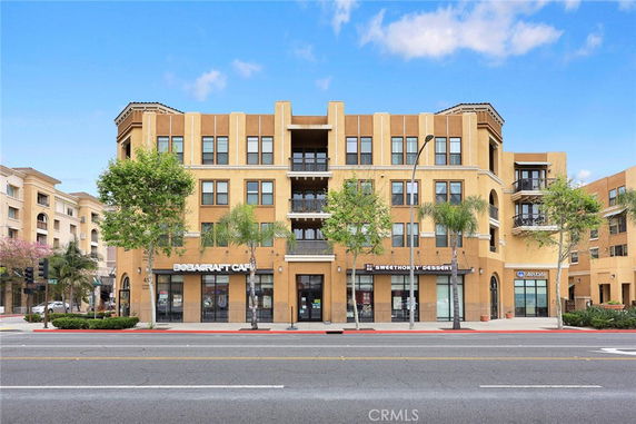 Front view of a multi-story commercial building with retail shops on the ground floor.