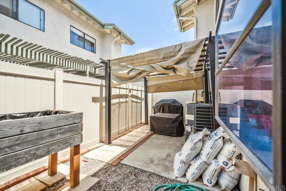 Outdoor area with covered patio and various equipment and items stored outside.