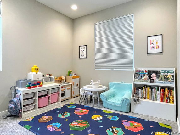 Indoor children's play area with toys, books, and a small table.