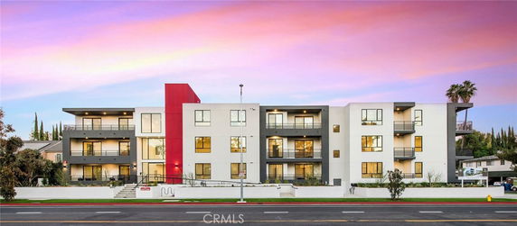 Front view of a modern multi-story apartment building with a colorful facade.