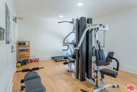 Indoor gym with fitness equipment and weights.