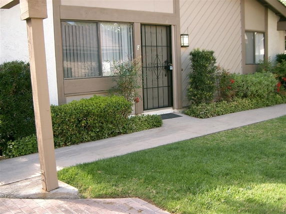 Front view of a house entrance with a metal security door and windows.