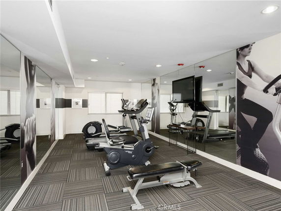 Room with exercise equipment including treadmills and a stationary bike.