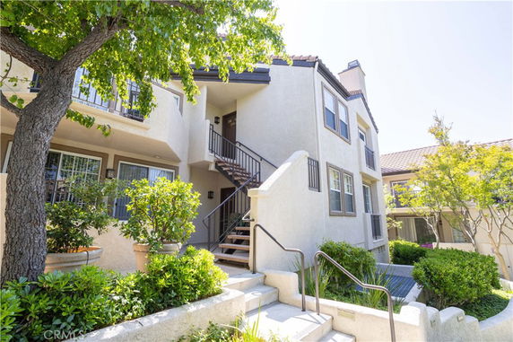Front view of a two-story residential building with outdoor stairs and balconies.