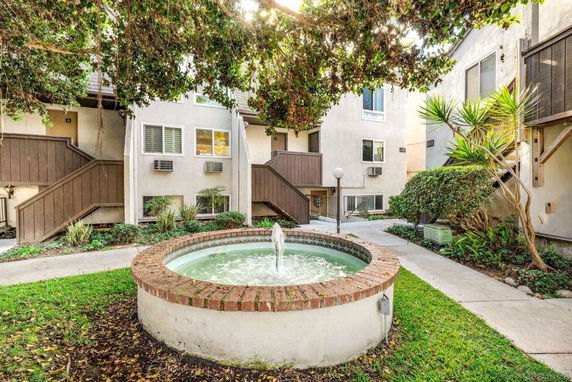 Courtyard view with a fountain surrounded by multi-story buildings.