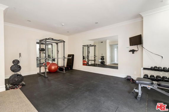 Indoor gym area with exercise equipment and a wall mirror
