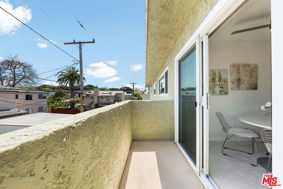 View from a balcony overlooking surrounding residential area with utility poles.
