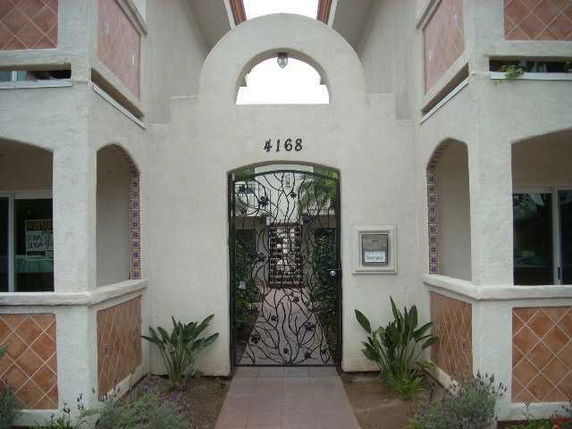 Front view of a building entrance with decorative metal gate and archway.
