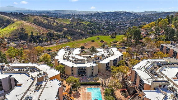 Panoramic view of a residential complex with surrounding hills and landscape.