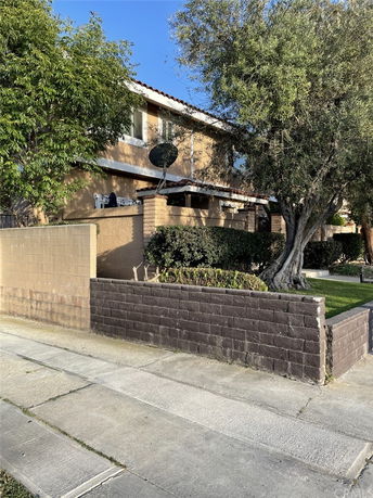 Front view of a two-story house with a brick wall and satellite dish.