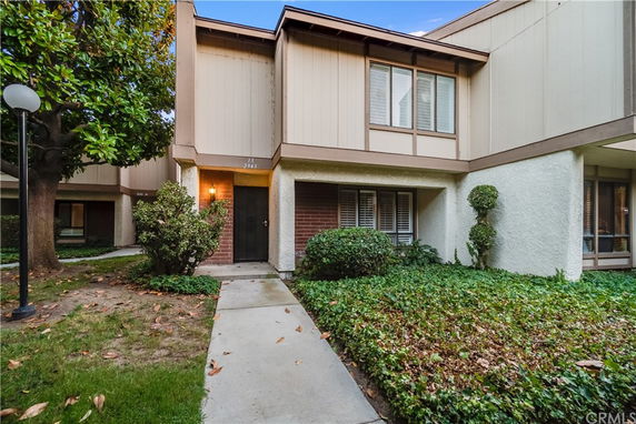Front view of a two-story townhouse with a brick and stucco exterior.
