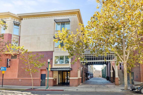 Front view of a multi-story building with brick and stucco exterior and a passageway.