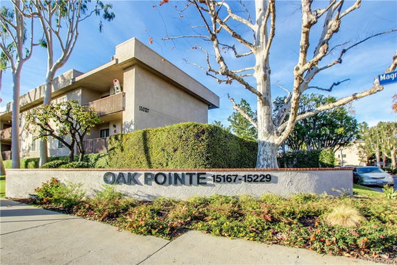 Front view of a multi-story building with wooden balconies and signage reading 'Oak Pointe'.