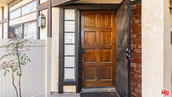 Front view of a house with a wooden door and adjacent window panels.
