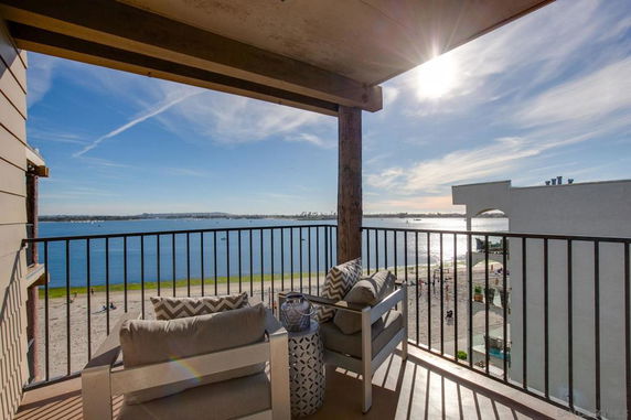Balcony view overlooking a body of water and beach area.