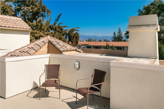 Rooftop area featuring two chairs and a partial view of surrounding buildings.