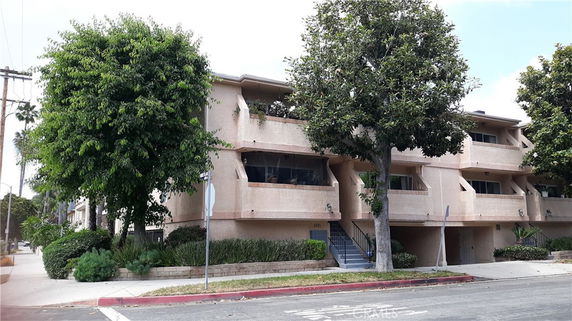 Front view of a multi-story residential building with balconies.