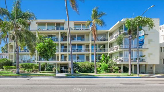 Front view of a multi-story apartment building with balconies.