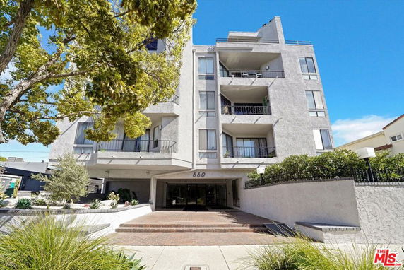 Front view of a multi-story residential building with balconies.