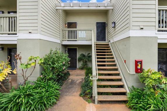Front view of a two-story building with an exterior staircase.