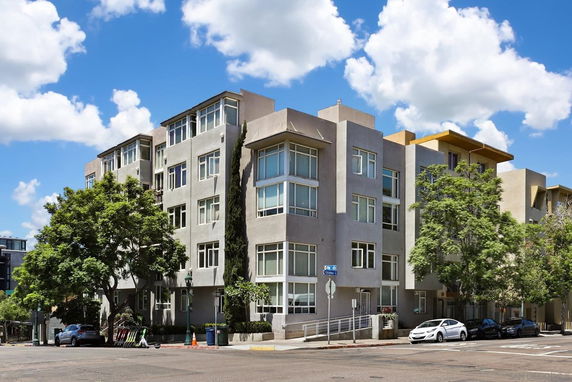 Front view of a multi-story residential building with large windows.