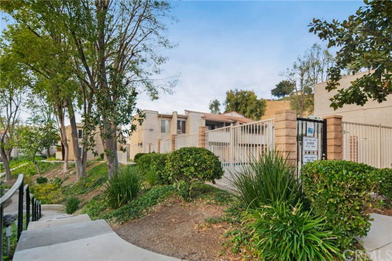 Front view of a multi-story residential building with a gated entrance.