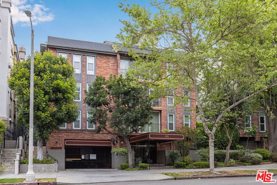 Front view of a multi-story building with brick facade and large windows.