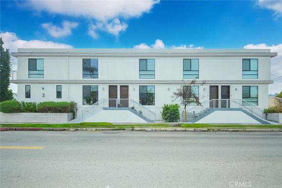 Front view of a two-story modern building with symmetrical design and dual staircases.