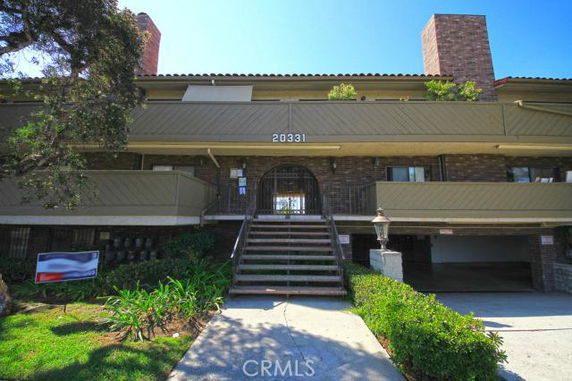 Front view of a multi-story residential building with a staircase leading to the entrance.