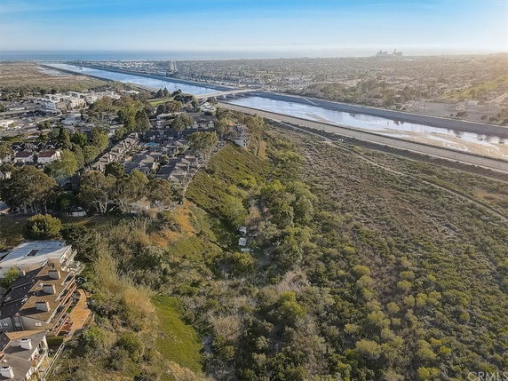 Panoramic view of a residential area with a river and cityscape in the background.