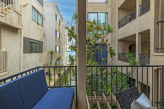 View from a balcony overlooking nearby apartment buildings and plants.