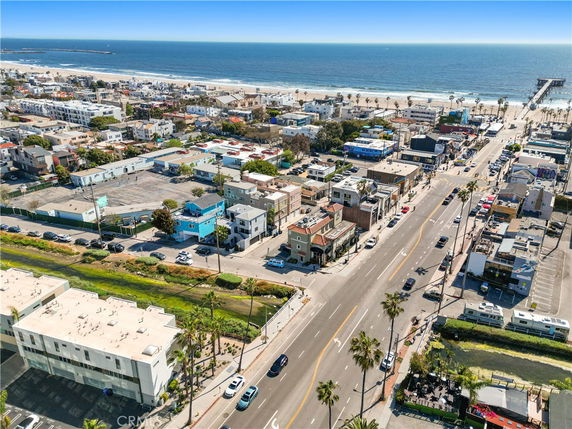 Aerial view of a coastal town with houses and streets near the ocean.