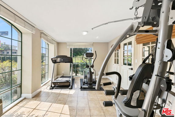 Indoor fitness area with exercise equipment and large windows