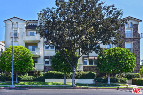 Front view of a multi-story apartment building with balconies.
