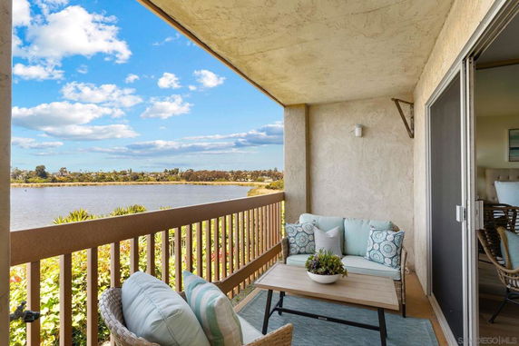 View from a balcony overlooking a lake and surrounding landscape.