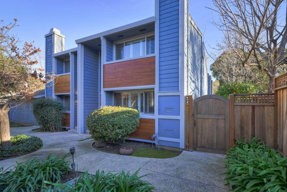 Front view of a two-story house with blue and wood accents.
