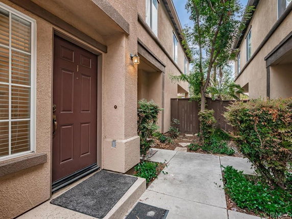 Front view of a townhouse entrance with a brown door and pathway.