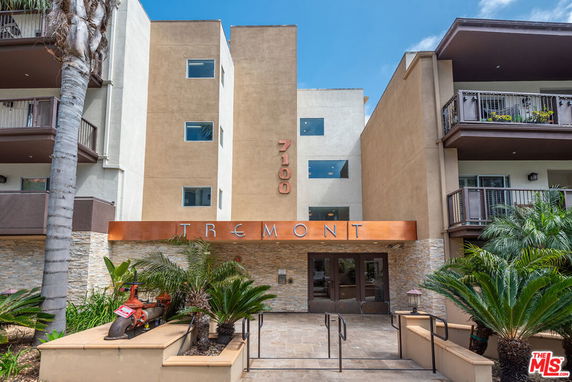 Front view of a modern multi-story building with balconies and entrance labeled 'Tremont'.