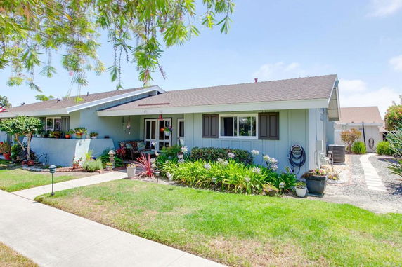 Front view of a single-story house with a sloped roof and garden.