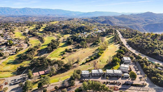 Panoramic view of a hilly landscape with buildings and a golf course.