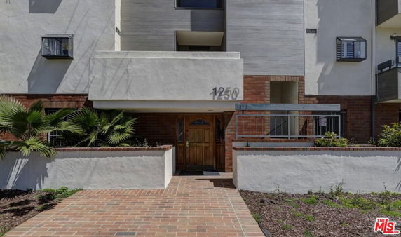 Front view of a building entrance with brick and stucco facade.