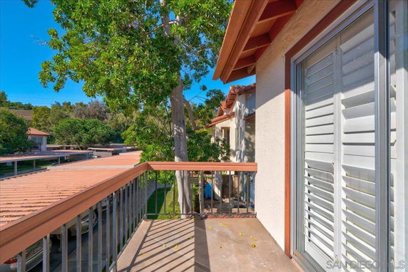 Balcony view showing trees and adjacent structures.