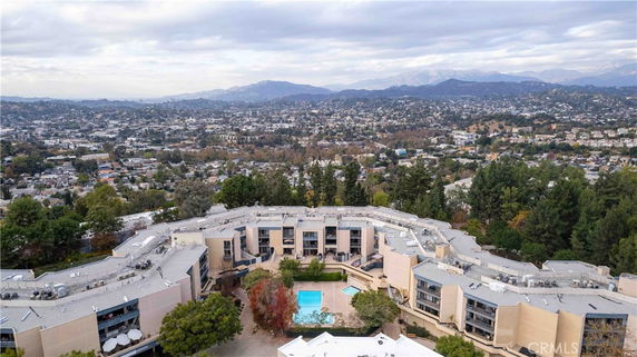 Panoramic view of a residential complex with a central swimming pool and surrounding landscape.