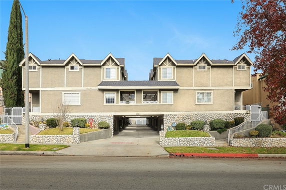 Front view of a multi-story building with a central driveway and stone accents.